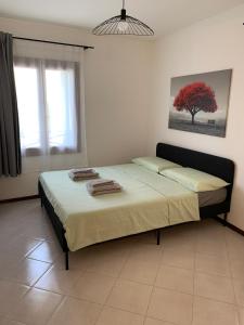 Un dormitorio con una cama grande con toallas. en ElenaM, en Udine