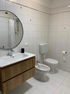 Un baño con inodoro, lavabo y espejo. en ElenaM, en Udine