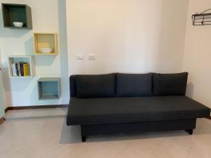 un sofá negro sentado en una habitación en ElenaM, en Udine