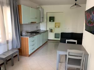 Una cocina con gabinetes azules y una mesa y sillas. en ElenaM, en Udine