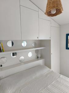 a white bedroom with a bed and white cabinets at Bardolino Blue in Bardolino