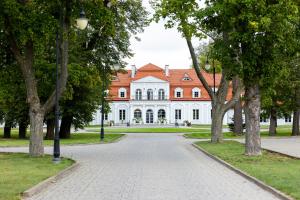 a large white building with a red roof at Pałac Domaniowski in Wieniawa