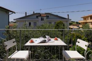 a table with a book and two chairs on a balcony at Appartamento Giglio in Numana