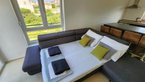 a bedroom with a bed and a couch and a window at The Sands LUXE Pool Aparthotel 6 in Novalja +22 photos