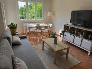 a living room with a couch and a tv and a table at Las Candelas, Casa Turística in Uruñuela