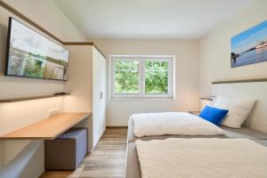 a bedroom with two beds and a desk at Kanalkajüte Wilhelm in Hanerau-Hademarschen