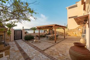 a patio with a wooden pergola and a table at Han’s Maisonette in Porto Heli