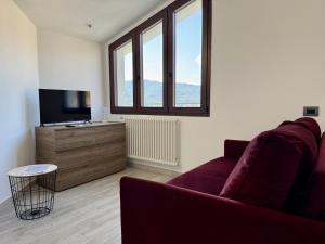 Una sala de estar con un sofá y un televisor de pantalla plana. en Villa Catocce - Beautiful New Apartments with Parking - by HOST4U, en Imperia