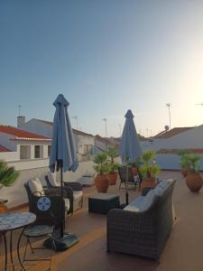 a patio with chairs and umbrellas on a roof at Pátio da Villa - Coruche Boutique Guest House in Coruche
