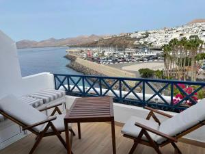 a balcony with chairs and a table and the water at Sol Y Mar in Puerto del Carmen