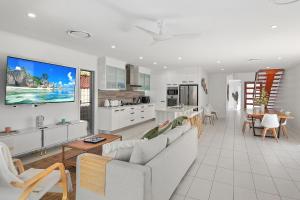 a white living room with a couch and a kitchen at Golden Beach Oasis - Sleeps 12 in Golden Beach