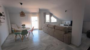 un salon avec un canapé, une table et des chaises dans l'établissement Apartamentos La Casa de Bebita, à Fuengirola