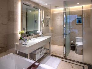 a bathroom with a sink and a shower and a toilet at Pullman Guiyang in Guiyang