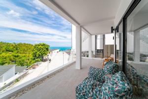 a living room with a couch and a view of the ocean at 2BR Emerald Villa Private Pool & Sea View B30-1 in Amphoe Koh Samui