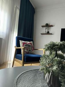 a living room with a blue chair and a table at napartmentss in Pristina