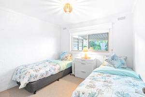 a bedroom with two beds and a window at Sandy Toes & Salty Kisses in Apollo Bay