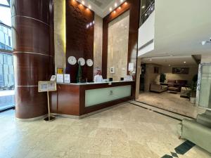 a lobby with a counter with clocks on the wall at فندق الميقات أجياد in Mecca