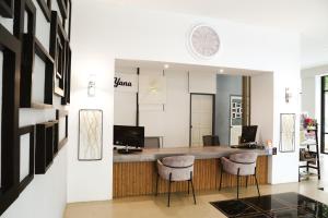 a lobby with a bar with stools and a clock on the wall at Di Yana Patong in Patong Beach