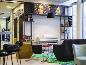 a lobby with chairs and a table and a piano at Aparthotel Adagio Köln City in Cologne