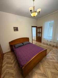 a bedroom with a large bed with purple sheets at Borytchyw in Kyiv