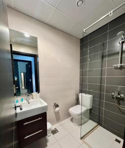 a bathroom with a toilet and a sink and a shower at Exquisite Home with Smart Office in Dubai