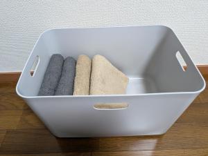 a white box with four towels in it on a floor at Moon Rising 102 in Takatsu-ku