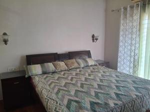 a bedroom with a large bed with two pillows at Sunrise Villa in Kharar