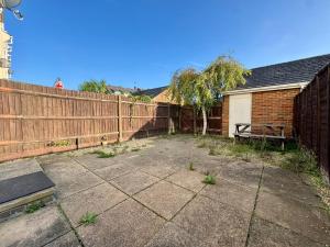 a backyard with a wooden fence and a building at Jessie Terrace Stays in Southampton