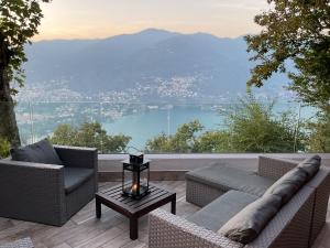 a patio with two couches and a table with a view at Baita Sorriso in Brunate