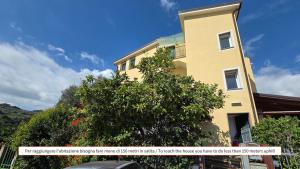 a yellow building with a tree in front of it at Sugheri di mare - By Ligooria in Pietra Ligure