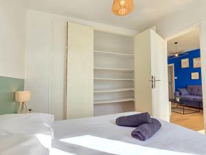 - une chambre avec un lit et des serviettes pourpres dans l'établissement Le Lagon, Moderne, Parking & Proche du Centre, à Saint-Brieuc