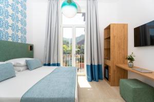 a bedroom with a bed and a tv and a window at Domus Gualtieri in Sorrento