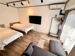 東京にあるLUCKY house53のベッド2台と薄型テレビ付きの部屋
