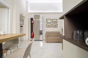 Una sala de estar con un sofá, una mesa y sillas. en Aras Luxury Flat, en Roma