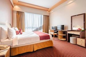 a hotel room with a large bed and a desk at Elite Resort & Spa in Manama