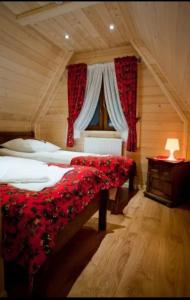 a bedroom with a bed with a red blanket and a window at Domek Deluxe Resort Willa Adrian in Zakopane