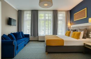 a hotel room with a bed and a blue chair at Hotel Villa Art Novis Wrocław Centrum in Wrocław