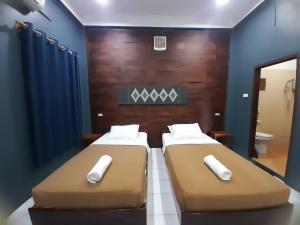 Dos camas una al lado de la otra en una habitación. en Oudomphong Guesthouse, en Luang Prabang