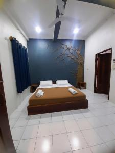 Un dormitorio con una cama con un cuadro en la pared. en Oudomphong Guesthouse, en Luang Prabang