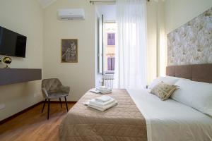 1 dormitorio con 1 cama con silla y TV en Aras Luxury Flat, en Roma