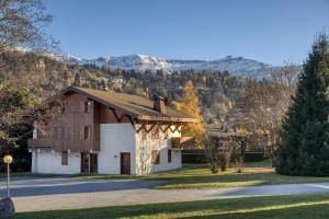 a building with a gambrel roof on a road at Séjour lumineux avec vue sur les cimes in Megève