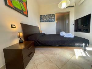 Un dormitorio con una cama, una cómoda y un televisor. en Monolocale sul fiume, en Calcinaia