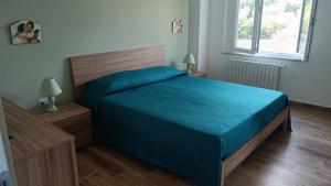 a bedroom with a bed with a blue comforter at Casa vacanze da Piera di Carta Giuseppina in Sassari