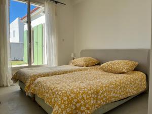 a bedroom with a bed with two pillows and a window at Rénovation d'Architecte- Mer &Phare à pied in Saint-Clément-des-Baleines