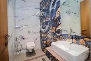 a bathroom with a sink and a toilet at Ascent Star Inn in Mumbai