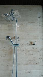 Un cabezal de ducha en una habitación con pared de madera en MD Hotel, en Mỹ Lộc