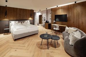 a hotel room with a bed and a couch at SONNENBERG Panorama Dolomites Wellbeing in Maranza +71 photos