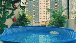 Una piscina azul en un balcón con edificios. en The Amethyst Nest Hanoi-Tranquil Stay with Rooftop & Coffee Shop-Near Old Quarter, en Hanói