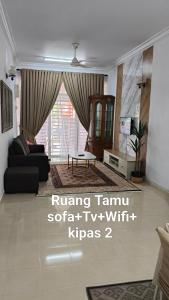 a living room with a couch and a table at D'Raudhah Homestay Binjai Kemaman 