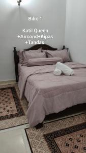 a bedroom with a bed with two towels on it at D'Raudhah Homestay Binjai Kemaman 